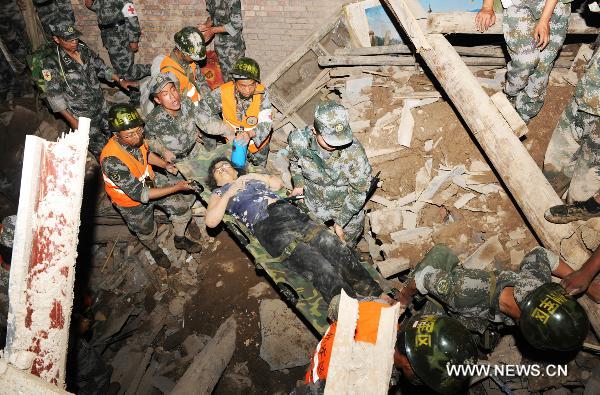 Soliders carry a survivor in landslide-hit Zhouqu County, Gannan Tibetan Autonomous Prefecture in northwest China&apos;s Gansu Province, Aug. 8, 2010. Soldiers sent by the Lanzhou Military Area Command of the Chinese People&apos;s Liberation Army have saved 9 people from rain-triggered landslides in Zhouqu County. [Xinhua]