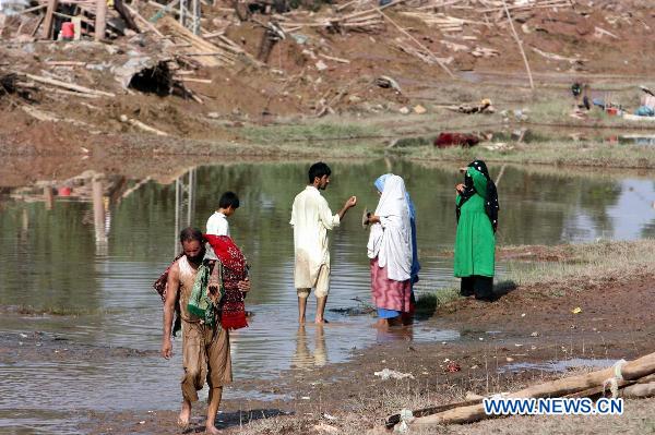 Pakistani villagers migrate with their belongings as their houses were flooded in northwest Pakistan&apos;s Charsadda, on Aug. 8, 2010. The worst floods in Pakistan since 1929 have left more than 14 million people in need of emergency assistance and at least 1,600 people killed. [Saeed Ahmad/Xinhua]