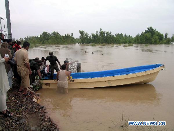 Pakistani army team prepare a boat to rescue villagers in northwest Pakistan&apos;s Charsadda, on Aug. 8, 2010. The worst floods in Pakistan since 1929 have left more than 14 million people in need of emergency assistance and at least 1,600 people killed. [Saeed Ahmad/Xinhua]