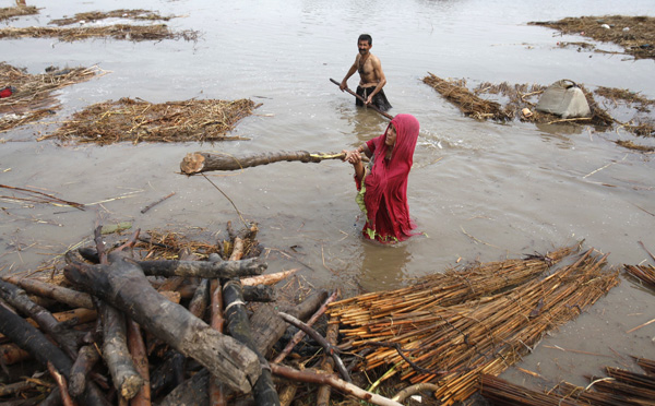 Flood victims collect wood from their destroyed house in Sukkur, in Pakistan&apos;s Sindh province August 8, 2010. Districts in Sindh province were on high alert on Saturday for floods which have devastated other parts of the country and cast fresh doubts over President Asif Ali Zardari&apos;s leadership. [Saeed Ahmad/Xinhua]
