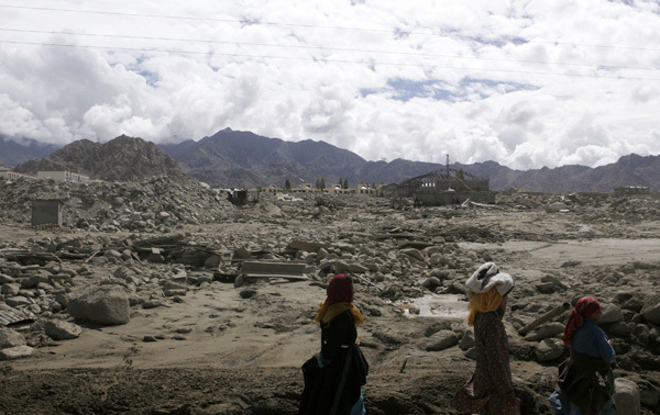 Flash flood victims walk past damaged structures in Leh, about 443 km (275 miles) east of Srinagar August 8, 2010. Flash floods killed at least 132 people around the main town of India&apos;s Himalayan region of Ladakh, officials said on Saturday, adding soldiers had been called in for rescue operations. [Saeed Ahmad/Xinhua]