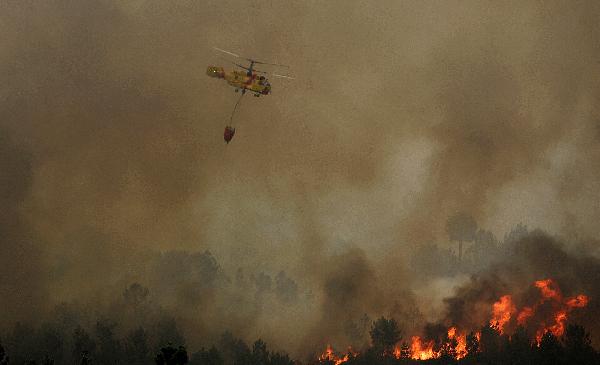 A helicopter drops water over a forest fire in Portugal Aug 8, 2010. More than 700 firefighters and soldiers are trying to extinguish dozens of forest fires in Portugal after temperatures rose up to 40 degree Celsius in several areas in the country.[Xinhua]