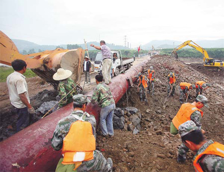 Soldiers work to fix the damaged water pipelines in suburban Tonghua. Four pipes connecting the city with a local water filtering plant were destroyed in floods caused by torrential rain. [China Daily] 