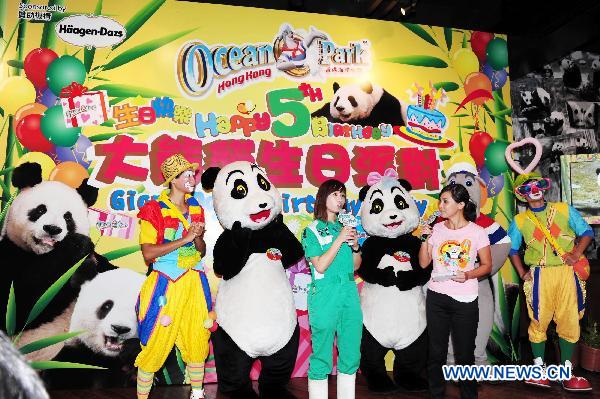 A zookeeper (3rd L) introduces the condition of giant pandas at the Ocean Park in Hong Kong, south China, Aug. 8, 2010. [Xinhua] 