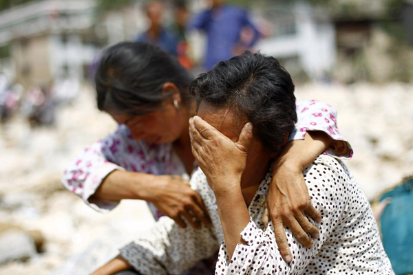 Women mourn their missing relatives in the landslide-hit Zhouqu County of Gannan Tibetan Autonomous Prefecture, Gansu Province August 9, 2010. [China Daily/Agencies]
