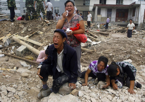 People mourn their missing relatives in the landslide-hit Zhouqu County of Gannan Tibetan Autonomous Prefecture, Gansu Province August 9, 2010. [China Daily/Agencies]