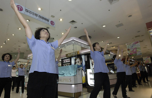 Sales staff at Xidan shopping center do radio gymnastic exercises before opening for business in downtown Beijing on Aug 8, 2010. Starting Monday, the municipality began broadcasting daily radio music to gymnastic exercises at 10 am and 3 pm, in a fitness campaign for all. [Xinhua] 