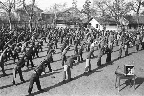 Students and faculty at a middle school in Shanghai do radio exercises in this file photo from Dec 1, 1951. Radio gymnastics exercise was introduced in China in 1951 to develop mass physical fitness, but the program was not kept up throughout the years due to various social changes. Beijing resumed the daily broadcast radio gymnastics exercise on Monday. [Xinhua] 