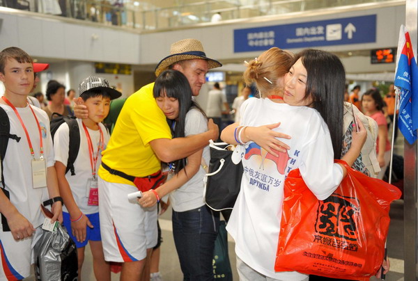 Chinese and Russian students hug each other at the Beijing Capital International Airport on August 9, 2010. A summer camp delegation of nearly 500 Russian students left Beijing after a 10-day trip across China. [Xinhua]