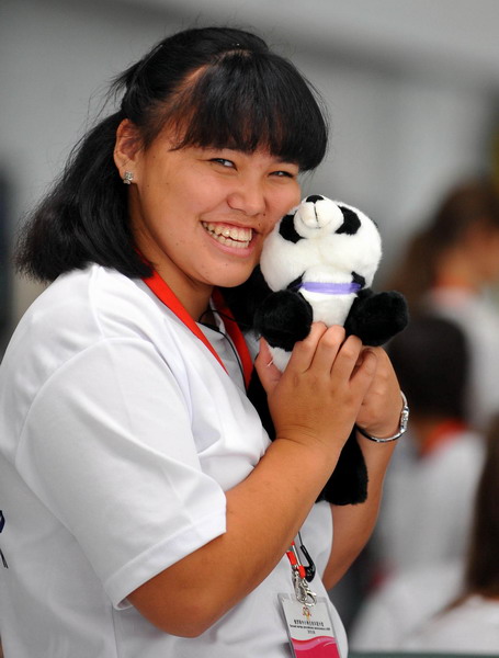A Russian girl poses with a giant panda doll at the Beijing Capital International Airport on August 9, 2010. [Xinhua]