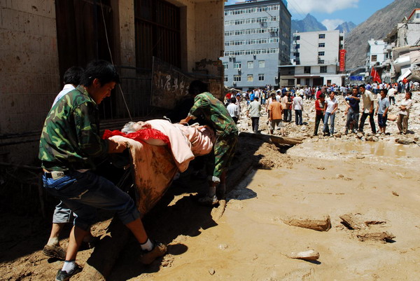 Rescuers carry a survivor out of the debris in mudslide-hit Zhouqu county, Northwest China&apos;s Gansu province, Aug 9, 2010. [Xinhua]