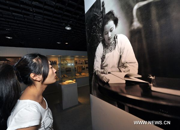 A visitor looks at a photo of Soong Ching-ling while she was young in Soong's former residence in Beijing, capital of China. [Xinhua/He Junchang]
