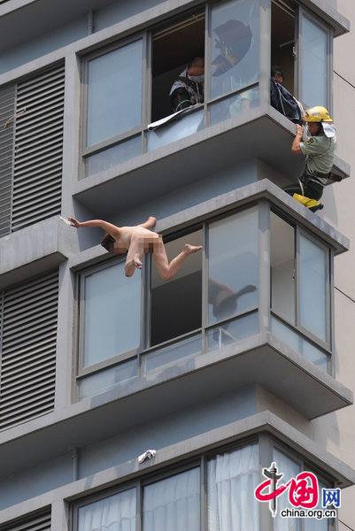 A woman jumps from her 11-floor-height home at a resident area on August 9, 2010 in Hefei, Anhui province of China. The woman have some mental problem and had been sent to hospital treatment by rescuer. [CFP]