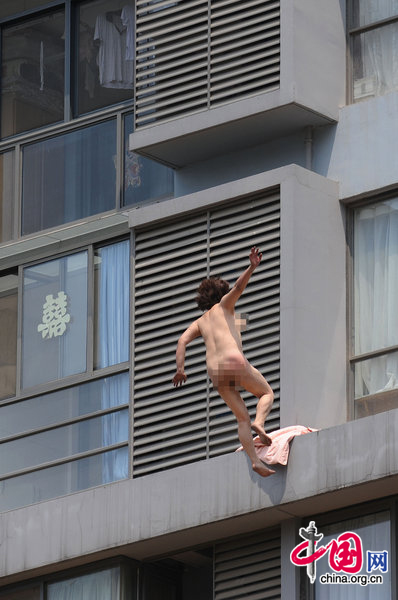 A woman jumps from her 11-floor-height home at a resident area on August 9, 2010 in Hefei, Anhui province of China. The woman have some mental problem and had been sent to hospital treatment by rescuer. [CFP]