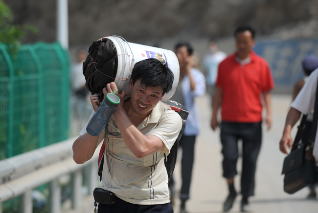 A man carries home relief materials in the landslides-hit Zhouqu County, Gannan Tibetan Autonomous Prefecture in northwest China&apos;s Gansu Province, Aug. 10, 2010. The rain-triggered landslide has caused 337 people dead and 1,148 others missing till 2:00 p.m. (0600 GMT) Monday. [Xinhua]