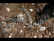 A bicycle wheel sinks in the mud, Aug 9, 2010.  [Xinhua]