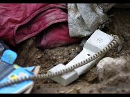 A broken telephone lies among the ruins, Aug 9, 2010. [Xinhua]