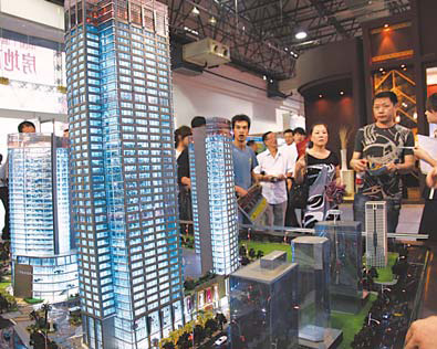 Visitors at a real estate expo in Wenzhou, Zhejiang province, check out property investment opportunities in the city. [China Daily]