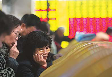 Residents of Wenzhou, Zhejiang province, check stocks at a brokerage in the city in this file photo. 