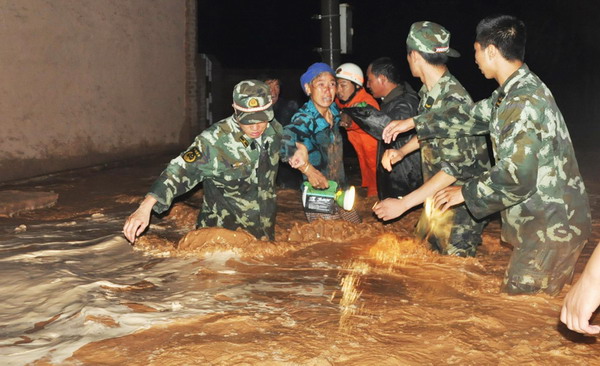 Armed Police officers rescue residents in Wuzhong city, Ningxia Hui autonomous region, from their flooded homes on Aug. 11, 2010. [Xinhua]
