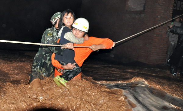 Armed Police officers rescue residents in Wuzhong city, Ningxia Hui autonomous region, from their flooded homes on Aug. 11, 2010. [Xinhua]
