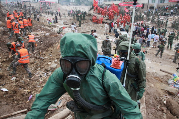 Troops from the People’s Liberation Army Lanzhou Military Area Command disinfect landslide-hit areas in Zhouqu, Gansu province, on Aug. 11, 2010. [Xinhua]