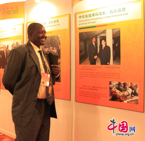 The photo shows an African representative looking at pictures in an exhibition on China-Africa relations at the China-Africa Agricultural Forum held in Beijing on August 11, 2010. [Xu Lin / China.org.cn]