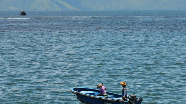 A fishing boat passes by a red tide-covered area in Shenzhen, a coastal city in South China’s Guangdong province, Aug 12, 2010. A new round of red tide hit Shenzhen on Thursday, following the large one on July 31, which covered 15 square kilometers of sea area at its peak. [Xinhua] 