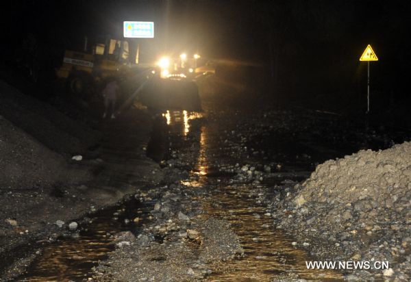A bulldozer cleans off mud and stones on a road in Wenxian County, northwest China&apos;s Gansu Province. Five villages of Wenxian County encountered with landslides triggered by continuous heavy rains, with no casaulties but nine residential houses, two roads and parts of power networks damaged. [Xinhua]