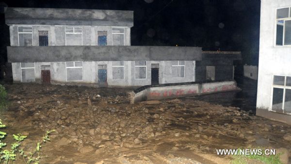 The photo taken late Aug. 12, 2010 shows mud and stones flooding into residential houses at Jiuguan Village of Wenxian County, northwest China&apos;s Gansu Province. Five villages of Wenxian County encountered with landslides triggered by continuous heavy rains, with no casaulties but nine residential houses, two roads and parts of power networks damaged. [Xinhua]