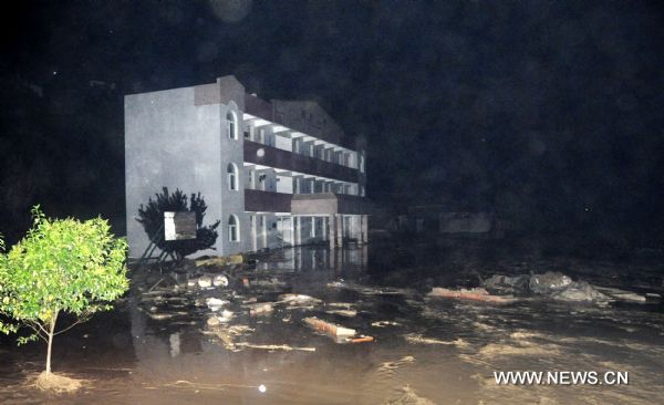 The photo taken late Aug. 12, 2010 shows a school submerged by flood at Jiuguan Village of Wenxian County, northwest China&apos;s Gansu Province. Five villages of Wenxian County encountered with landslides triggered by continuous heavy rains, with no casaulties but nine residential houses, two roads and parts of power networks damaged. [Xinhua]