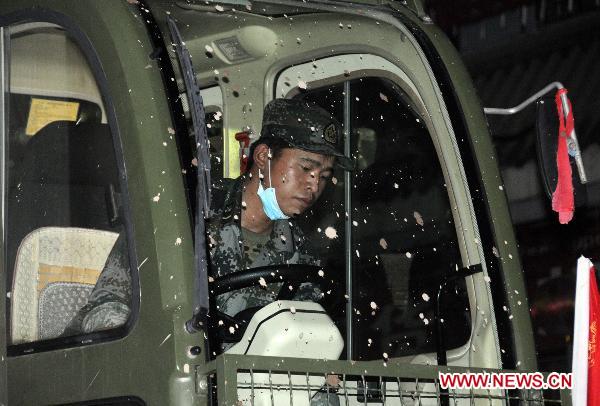 A soldier drives a shovel truck to clear up road surface in landslide-hit Zhouqu County, northwest China's Gansu Province, early Aug. 13, 2010. Rescuers are busy clearing away ruins and garbage after the landslide. All the ruins and garbage will be dealt with epidemic prevention measures.