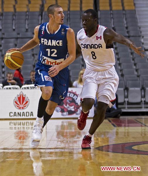 Nando De Colo (L) of France's Men's National Basketball Team drives the ball during the exhibition game against Team Canada at Air Canada Center in Toronto, Canada, on Aug. 12, 2010. Team Canada won the match 69-58.