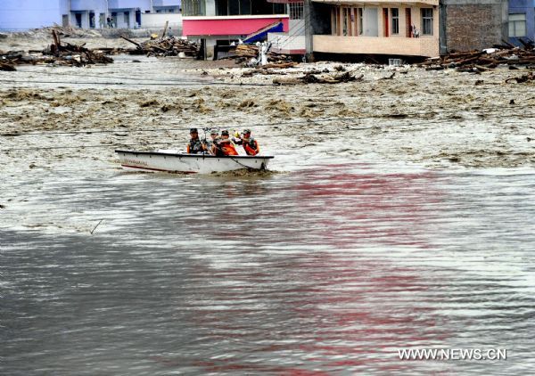 Soldiers settle explosives to dredge water channel in landslide-hit Zhouqu County, Gannan Tibetan Autonomous Prefecture in northwest China's Gansu Province. Over 80 multi-storeyed buildings are still in seriously ponding area, with water depth of 3-5 meters at present.