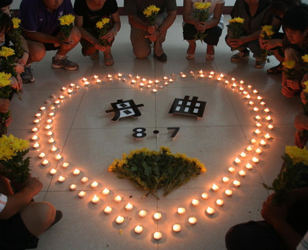 Children at a kindergarten in Tancheng county, Shandong province, hold a candlelight vigil in memory of Zhouqu landslide victims on August 14, 2010. Chinese flags across the country and at overseas embassies and consulates are to be lowered to half-staff Sunday to mourn the victims of the devastating mudslide in the Northwestern Gansu province, the State Council announced Saturday. Public entertainment will also be suspended Sunday in a show of mourning.[Xinhua]