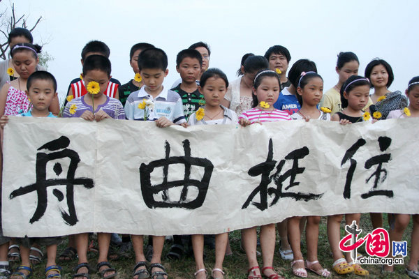 Children in Hanshan county, Anhui province, hold yellow chrysanthemum flowers in memory of Zhouqu landslide victims on August 14, 2010. [CFP]