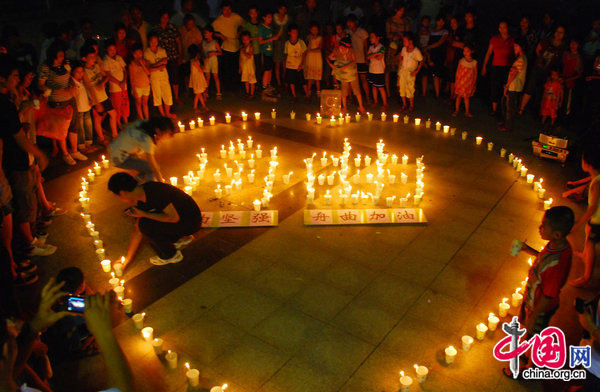Resident light candlelights to mourn for the victims of the mudslide disaster in Zhouqu on August 14, 2010. [CFP]
