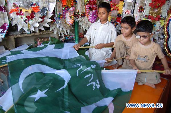 Pakistani boys purchase national flags to celebrate the Independence Day in northwest Pakistan's Peshawar Aug. 14, 2010. [Xinhua]