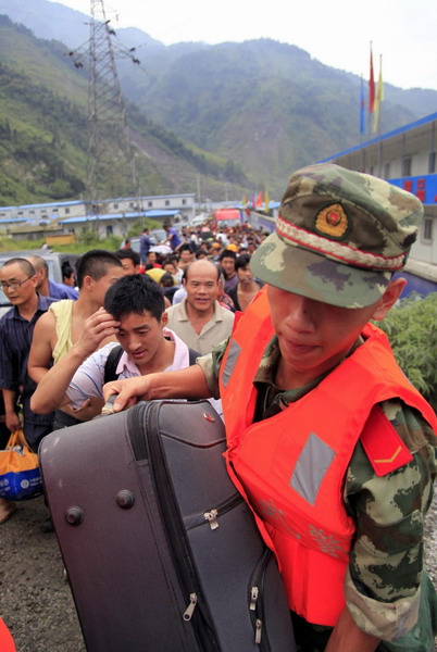 A rescuer is seen helping the affected residents after the landslides hit Wenchuan county, Sichuan province, August 14, 2010.[Photo/Xinhua]