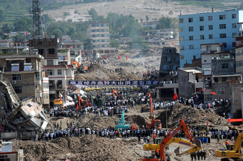 People stand in silent tribute to mourn the mudslide victims at the Dongjie Village in Zhouqu Country of Northwest China&apos;s Gansu province, the site of the devastating mudslide hitting one week ago on August 15, 2010. China observed a day of national mourning on Sunday for the victims. 1,239 people have been confirmed dead and 505 are listed as missing. [Xinhua]