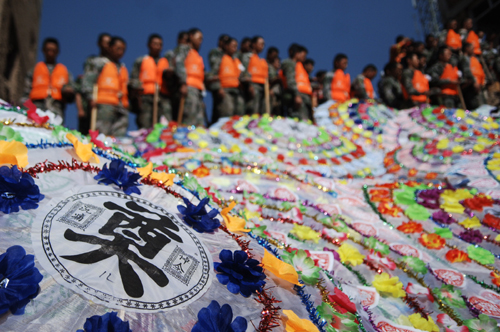 Rescuers stand in silent tribute to mourn the mudslide victims at the Dongjie Village in Zhouqu Country of Northwest China&apos;s Gansu province, the site of the devastating mudslide hitting one week ago on August 15, 2010. [Xinhua]