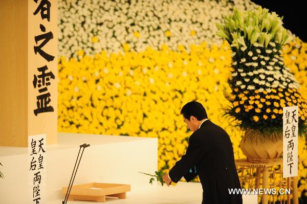 Japanese Prime Minister Naoto Kan places flowers at an alter in a memorial service for those who died in World War Two during a ceremony marking the 65th anniversary of Japan&apos;s surrender in the war, in Tokyo Aug. 15, 2010. [Xinhua] 