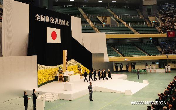  People walk to place flowers before an alter at a memorial service for those who died in World War Two during a ceremony marking the 65th anniversary of Japan&apos;s surrender in the war, in Tokyo Aug. 15, 2010. [Xinhua] 