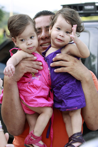 Siamese twins Hannah Yinneth (L) and Hannah Yanneth are carried by their father Alfredo Fernandez as they attend their first birthday party in Panama City August 14, 2010. The sisters, who are joined at the liver, will undergo an operation on August 23 that aims to separate them. Their mother, Sara Gil, 21, said although she hopes the twins&apos; lives will be better when they are separated, there is a possibility that one or even both of them could lose their lives as a result of the operation.[Xinhua/Reuters ]