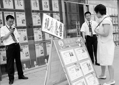 Employees of a real estate agency loitering outside their office in Beijing as property sales slow down. House prices in China's 70 major cities grew 10.3 percent year-on-year in July, the slowest growth pace since February this year.
