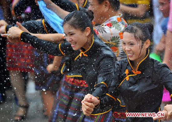 People spray water to each other for blessing during the Water Festival in Baoting Li and Miao Autonomous County, south China's Hainan Province, Aug. 16, 2010. The Water Festival on July 7 of Chinese traditional lunar calendar is the most important festival for Li and Miao people.