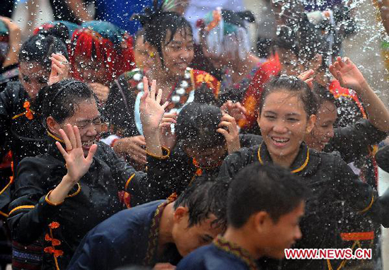 People spray water to each other for blessing during the Water Festival in Baoting Li and Miao Autonomous County, south China's Hainan Province, Aug. 16, 2010. The Water Festival on July 7 of Chinese traditional lunar calendar is the most important festival for Li and Miao people.