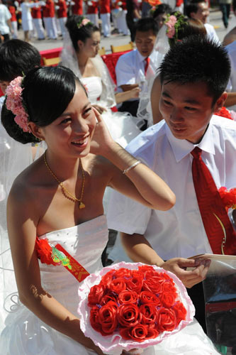 A new couple is among 77 pairs to hold a group wedding ceremony in Lushan county, Central China&apos;s Henan province, Aug 16, 2010. [Xinhua]
