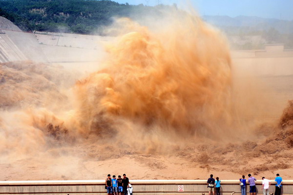 Spectators observe the flood discharge process at the Xiaolangdi Reservoir on the Yellow River in Jiyuan, Central China&apos;s Henan province, August 16, 2010.[Xinhua]