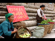Local residents sell vegetables at a temporary open marke in Zhouqu, Aug 14, 2010. [Xinhua]